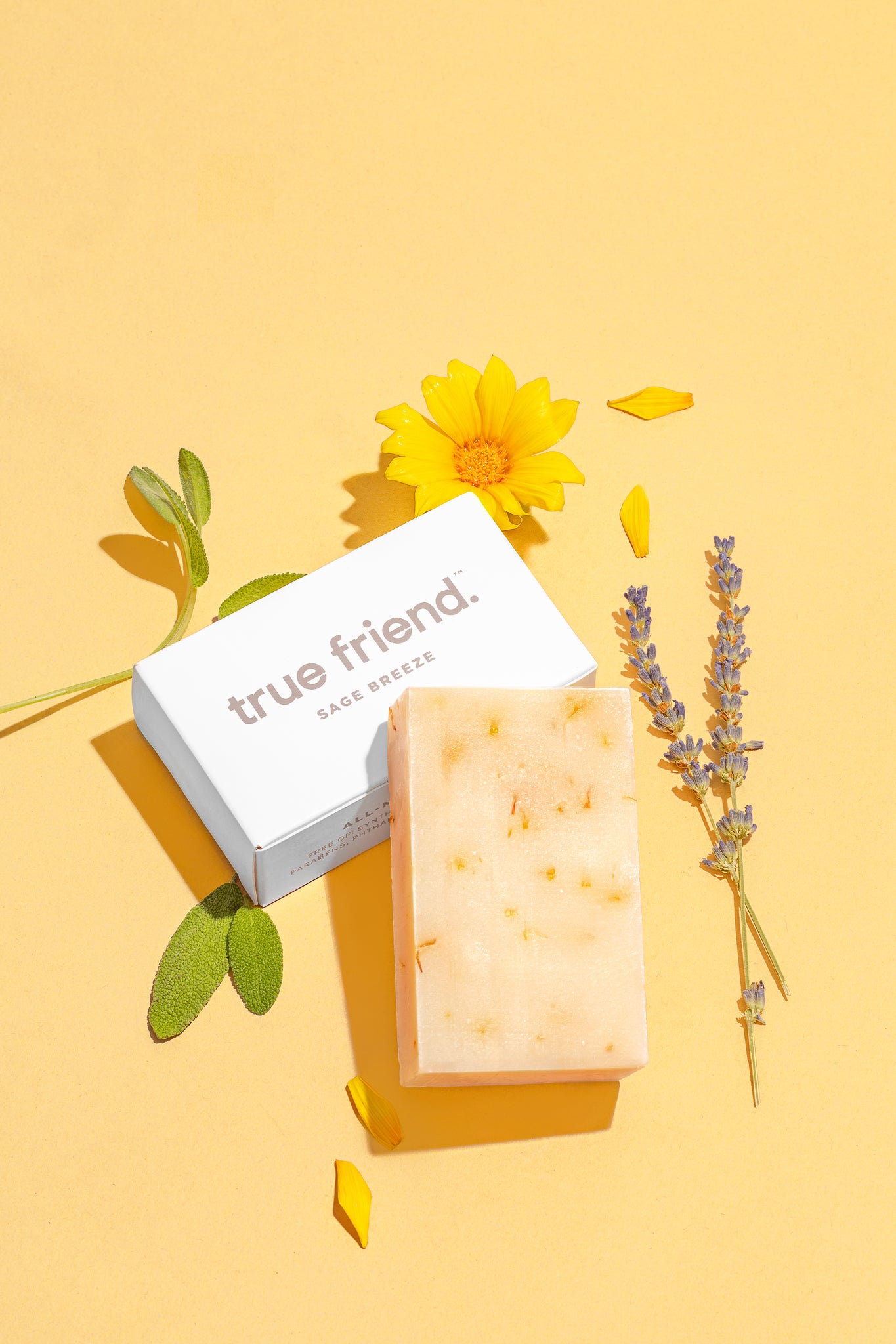 true friend sage breeze soap bar with True Friend packaging. Yellow flowers, and lavender on a yellow background